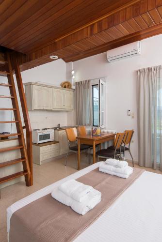 a bedroom with a bed and a table and a kitchen at Villa Christina in Nafplio