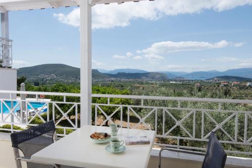 una mesa blanca y sillas en un balcón con vistas en Villa Christina, en Katsíngrion