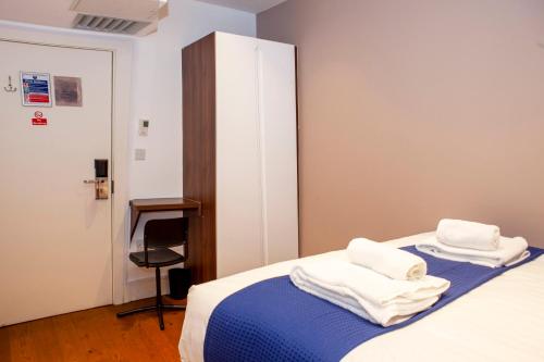 a bedroom with a bed with white towels on it at Putera Puteri Residence in London
