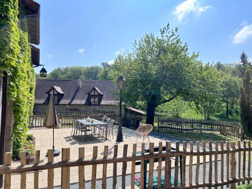 a wooden fence with a table and chairs in a yard at Lac privé, forêt, calme absolu dans un gîte tout confort in Saint-Estèphe