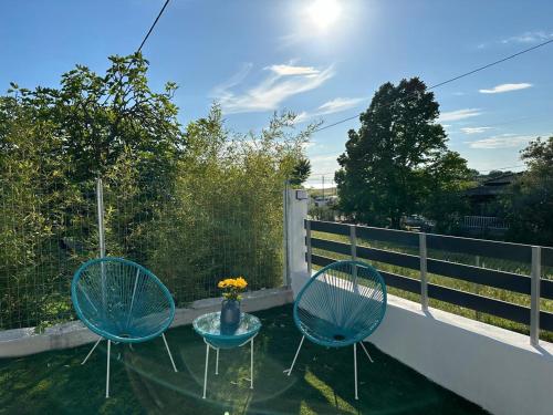 two blue chairs and a table on a balcony at Astre&Jeanne suites in Sozopoli