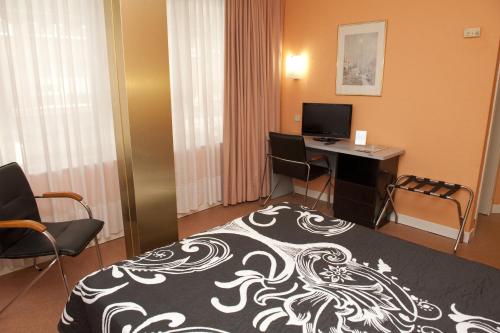a hotel room with a bed and a desk with a computer at Hotel Arha Santander in Santander