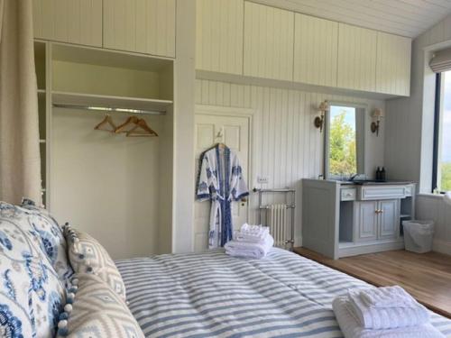 a bedroom with a large bed and a kitchen at Harry's Cottage in Aghanloo