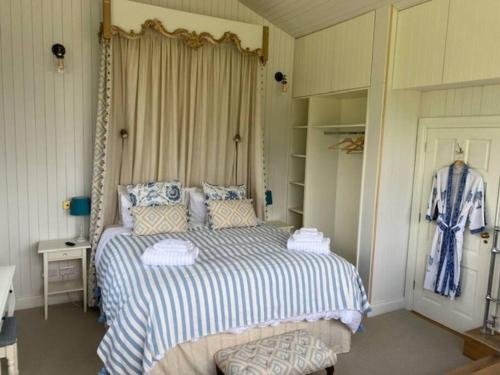 a bedroom with a bed with a blue and white blanket at Harry's Cottage in Aghanloo