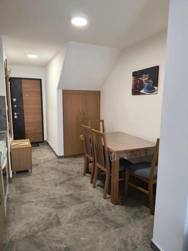 a dining room with a wooden table and chairs at MP Apartman in Soko Banja