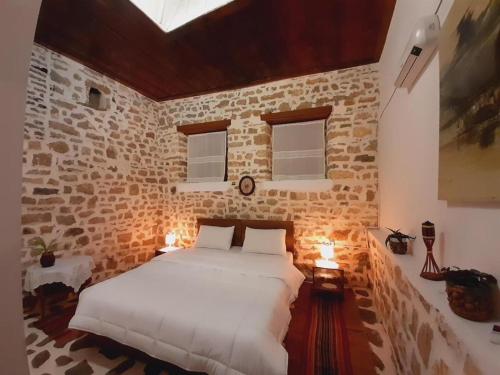 1 dormitorio con 1 cama grande en una pared de ladrillo en Edward Lear, en Berat