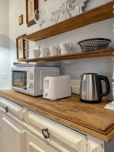 a kitchen counter with a microwave and a toaster at Charmante girondine avec jardin, proche St-Émilion in Libourne