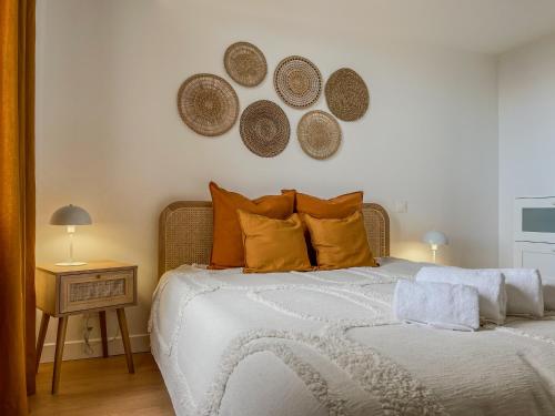 a bedroom with a bed with orange pillows and a mirror at Charmante girondine avec jardin, proche St-Émilion in Libourne