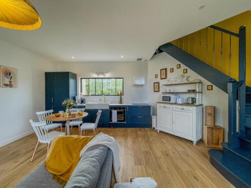 a kitchen and living room with blue cabinets and a table at Charmante girondine avec jardin, proche St-Émilion in Libourne