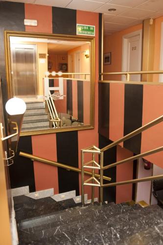 a hallway with a mirror and stairs in a building at Hotel Arha Santander in Santander
