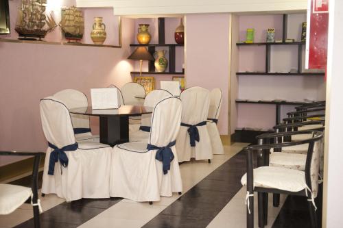 a dining room with white chairs and a table at Hotel Arha Santander in Santander