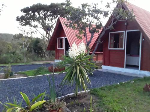 a small red house with a red roof at Pousada Cabanas in Alto Paraíso de Goiás