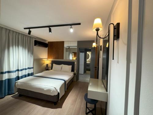 - une chambre avec un lit et un bureau avec un miroir dans l'établissement relaxinn marmaris, à İçmeler