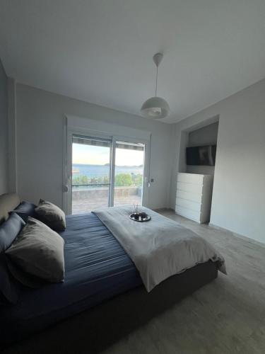 a bedroom with a large bed with a large window at Villa Thalia in Kavala