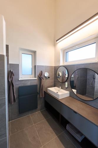 a bathroom with a sink and two mirrors at Apartments Vineyard19 in Retz