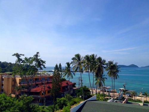 a view of a resort with palm trees and the ocean at Seaview At Cape Panwa in Panwa Beach