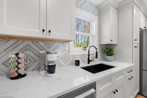 a kitchen with white cabinets and a counter top at Outdoor Projector, Arcade, Fire Pit, 2 Car Garage, 2 Living Rooms in Snellville