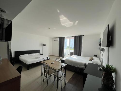 Habitación de hotel con 2 camas y mesa en Playa Blanca Beach Rentals, en Playa Blanca