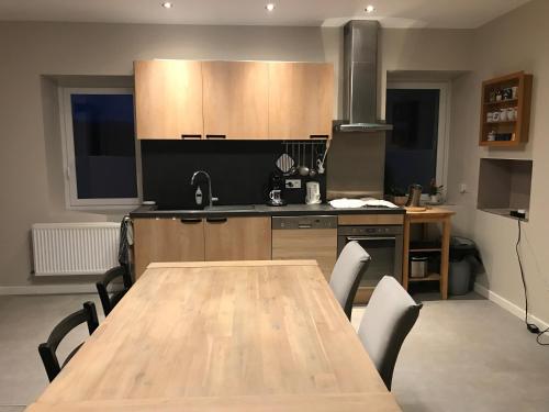a kitchen with a wooden table with chairs around it at Escale in La Motte-Servolex