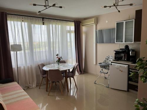 eine Küche und ein Esszimmer mit Tisch und Stühlen in der Unterkunft Lighthouse Golf Resort & Spa Apartments in Baltschik