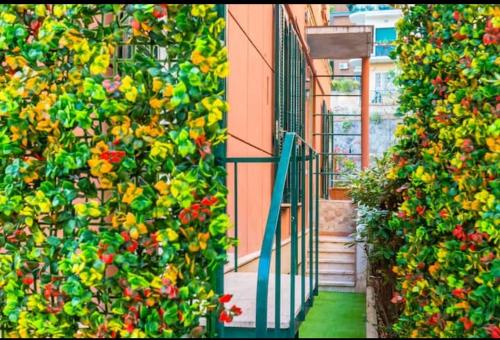 Un edificio con una barandilla verde y flores. en Napoli Relax Rooms Chiaia - Mergellina - Posillipo, en Nápoles