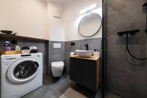 een badkamer met een wasmachine en een wastafel bij Belgrade Apartment Nook 1 in Belgrado