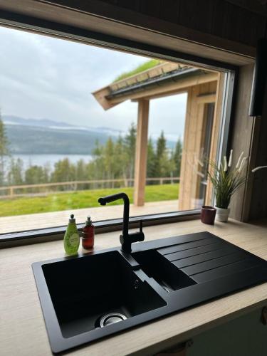 a kitchen counter with a sink and a window at Snowcake Cottage in Sør-Fron