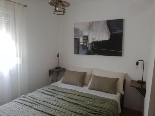 - une chambre avec un lit et une photo sur le mur dans l'établissement House Lily, à Šibenik