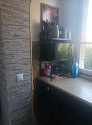 Cette chambre dispose d'un comptoir avec une fenêtre et une étagère. dans l'établissement Appartement cosy, à Choisy-le-Roi