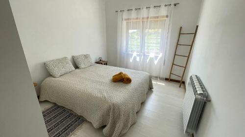 a teddy bear sitting on a bed in a bedroom at Quinta da Luena in Candemil