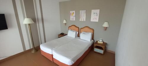 Domina Coral Bay - Private One Bedroom Aparthotel في شرم الشيخ: غرفة نوم بسرير ذو شراشف ووسائد بيضاء