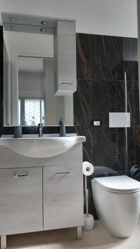 a bathroom with a white sink and a toilet at Casa Luce in Marina di Massa