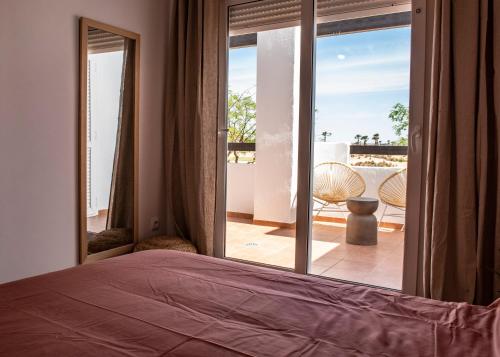 a bedroom with a bed and a view of a balcony at Chill y golf en Torre-pacheco in Murcia