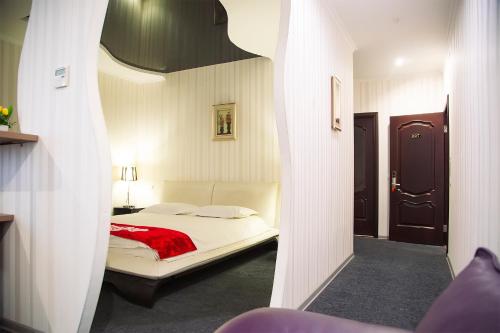 Un pat sau paturi într-o cameră la Hotel & Fitness Center MANDARIN