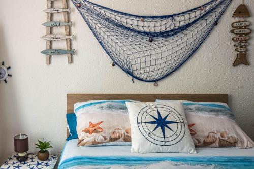 - une chambre avec un lit et un hamac sur le mur dans l'établissement La cabane bleue, T1 à Narbonne, à Narbonne