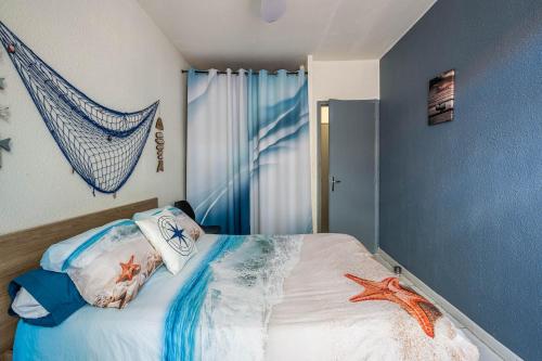 1 dormitorio con 1 cama con una red en la pared en La cabane bleue, T1 à Narbonne en Narbona