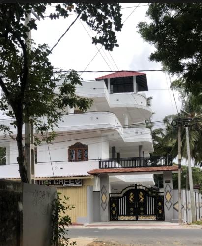 um edifício branco com uma varanda e um portão em SARMA VILLA em Tirunelveli East