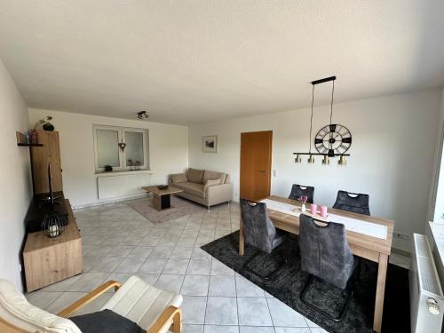 a living room with a table and chairs and a couch at Ferienwohnung Eifel-Ring in Siebenbach