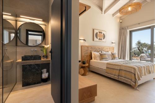 a bedroom with a bed and a mirror at Luxury Stone Villas Kefalonia in Trapezaki