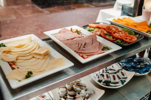 a buffet with several plates of food on a table at hotel plaza BRISAS MT in Punta Cana