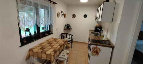 a small kitchen with a table and a refrigerator at Várlak vendégház in Mórahalom