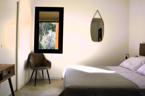 a bedroom with a bed and a mirror and a chair at Il Giardino del Tempio in Agrigento