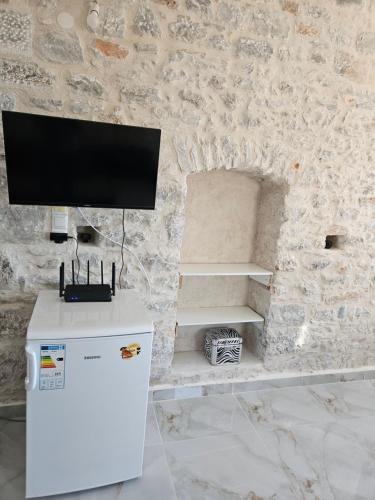 a room with a tv on a stone wall at Rigas stone tower east Mani 1 in Mína