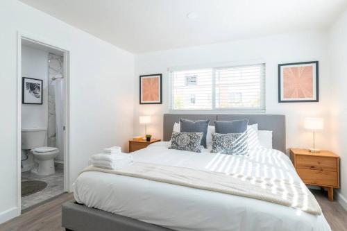 a white bedroom with a large bed and a bathroom at New DT Alhambra Family Vacation Home with King Bed in Alhambra