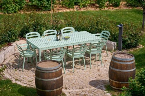 a green table and chairs and a table and barrels at Apartments Vineyard19 in Retz