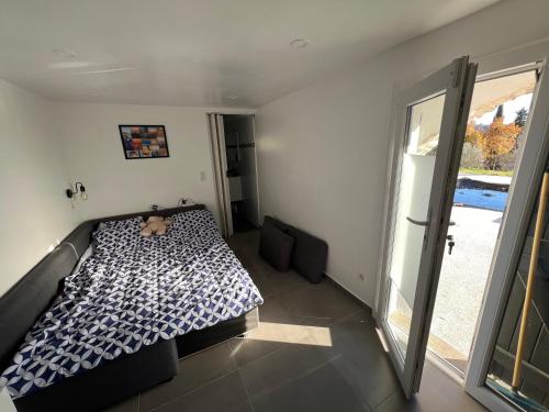 une chambre avec un lit et une grande fenêtre dans l'établissement Independant Cosy Flat, à Peymeinade