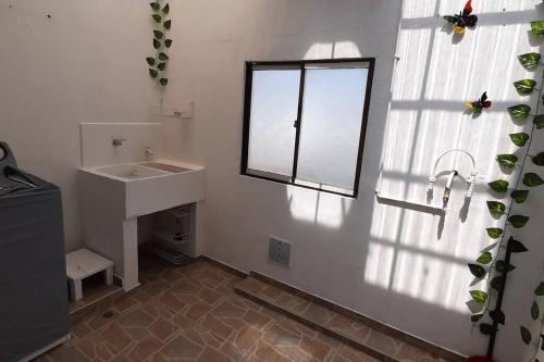 baño con lavabo y ventana en Apartamento completo cerca a embajada 3, en Bogotá