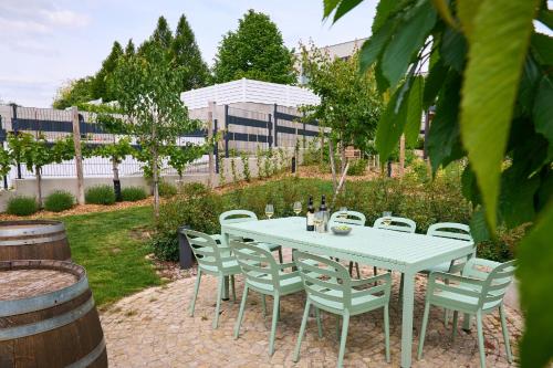 a white table and chairs in a garden at Apartments Vineyard19 in Retz