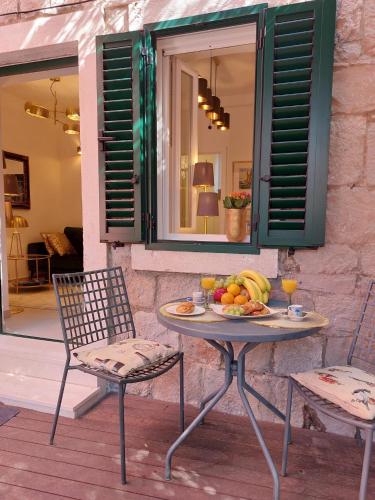 a table with a plate of fruit and two chairs at Split Old Town Oasis in Split