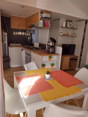 a kitchen with a table and chairs and a kitchen with a table and a table at Mobil home emplacement 38a in Les Mathes